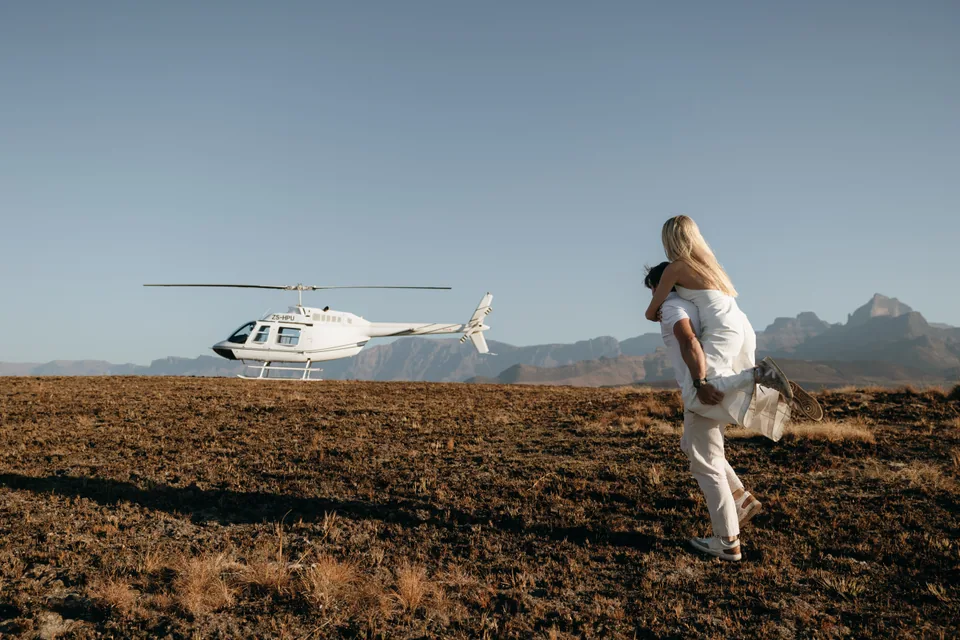 Joshua carrying Christy towards the helicopter
