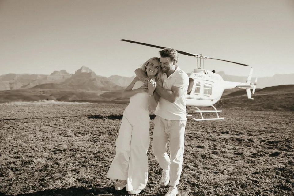Christy and Joshua holding each other beside the helicopter