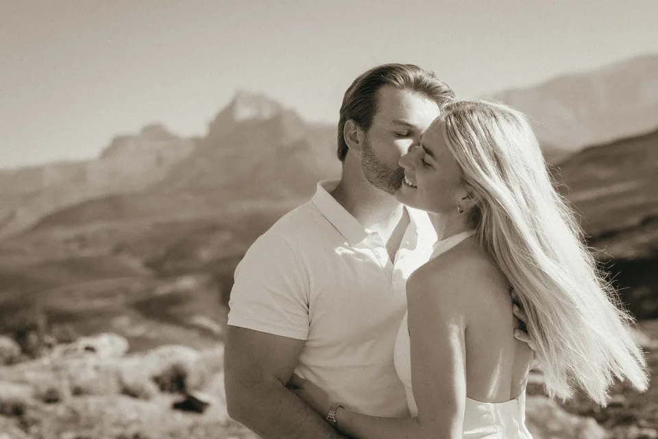 A kiss, close, with the mountains beyond