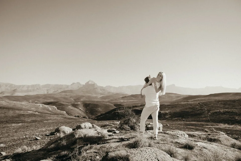Joshua lifting Christy on a rocky outcrop above the valley