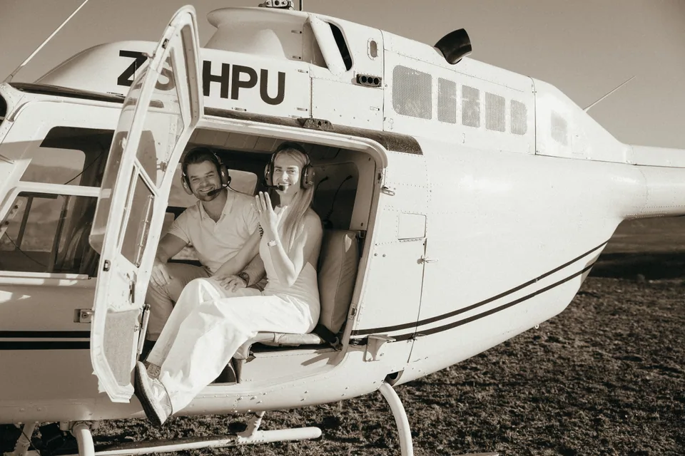 Sitting in the open door of the helicopter