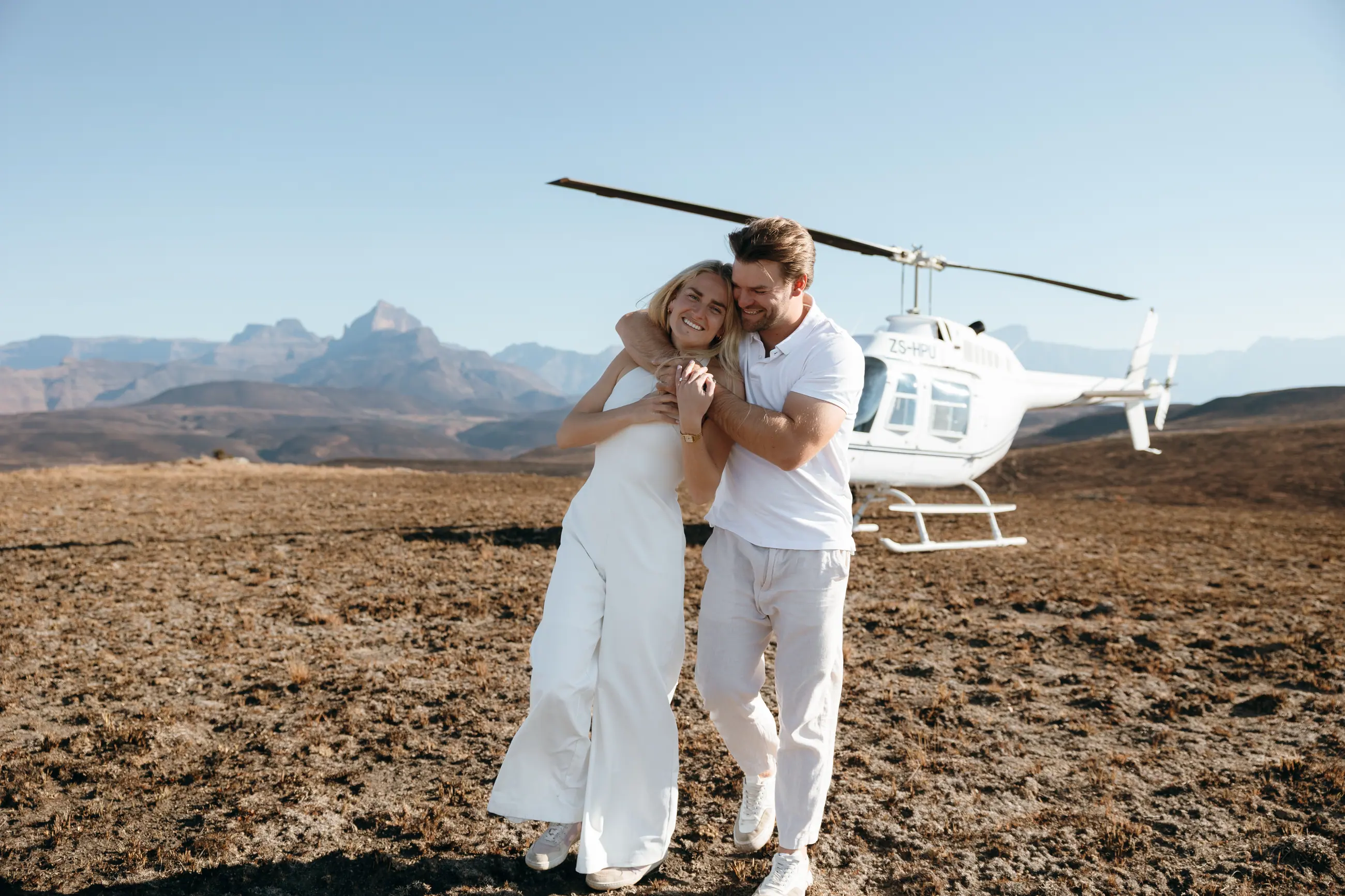 Christy and Joshua embracing beside the helicopter after the proposal