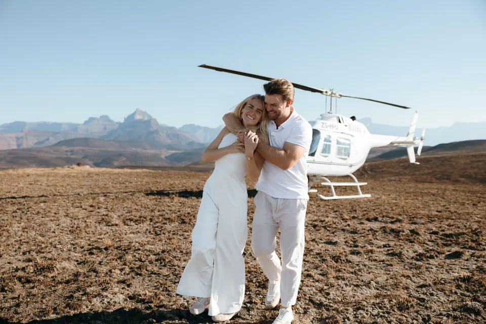 Christy and Joshua embracing beside the helicopter after the proposal